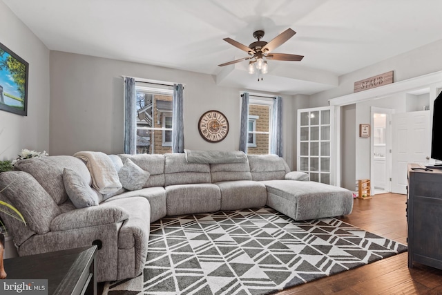 living room featuring wood-type flooring and ceiling fan