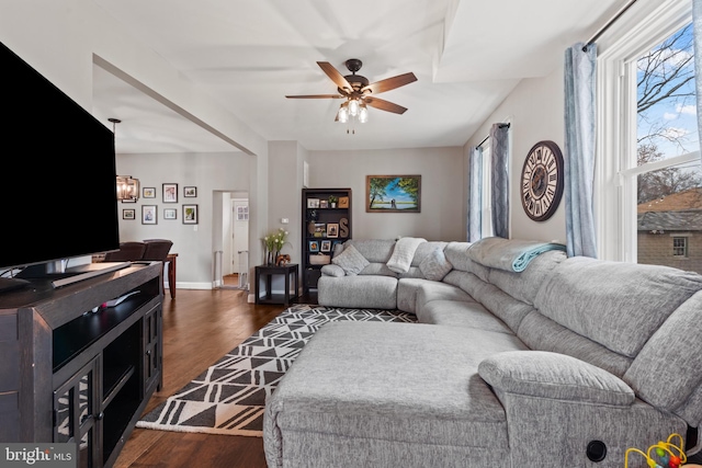 living room featuring dark wood-type flooring and ceiling fan