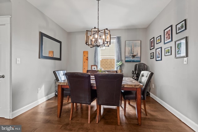 dining space with dark hardwood / wood-style floors and a chandelier