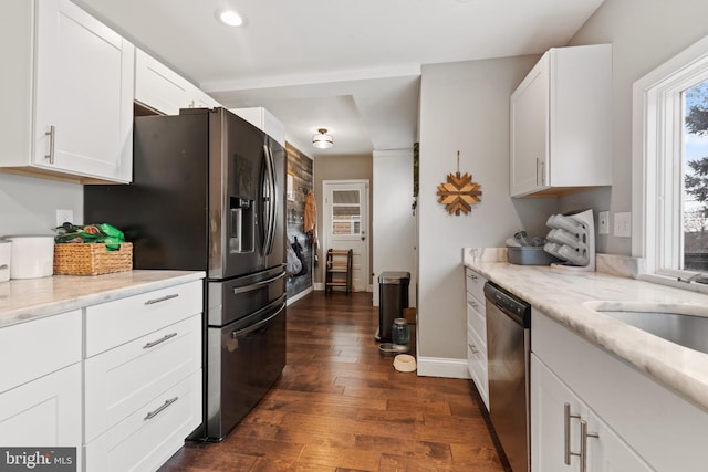 kitchen featuring light stone counters, dark hardwood / wood-style flooring, stainless steel appliances, and white cabinets