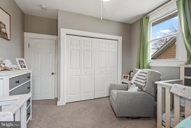 bedroom featuring light carpet and a closet