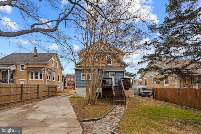 rear view of house featuring a wooden deck and a lawn