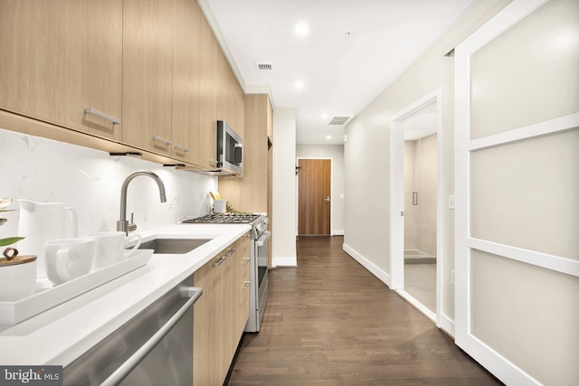 kitchen featuring light brown cabinetry, sink, appliances with stainless steel finishes, dark hardwood / wood-style floors, and backsplash