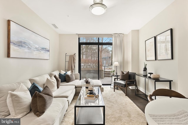 living room with dark wood-type flooring and floor to ceiling windows