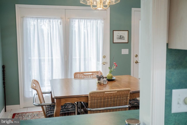 tiled dining space featuring a notable chandelier