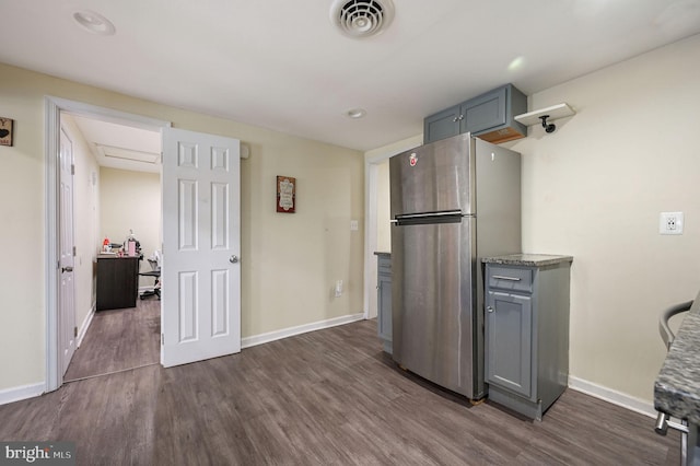 kitchen featuring dark hardwood / wood-style floors, gray cabinetry, and stainless steel refrigerator