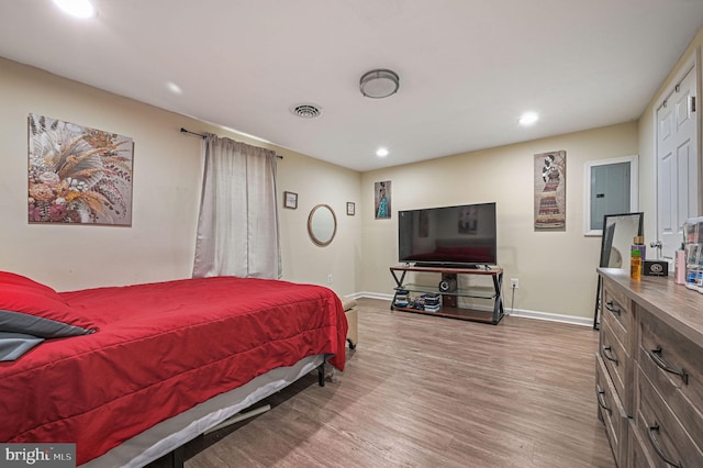 bedroom featuring electric panel and light hardwood / wood-style flooring