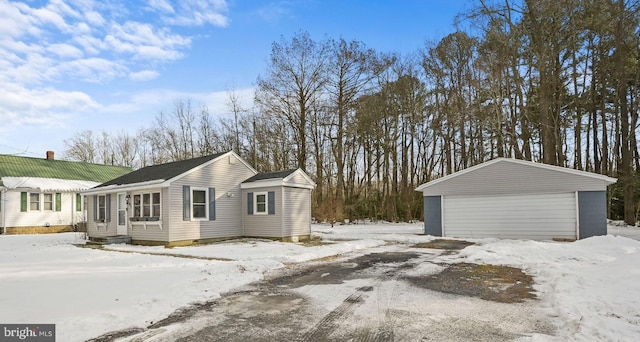 view of snow covered exterior with a garage and an outdoor structure