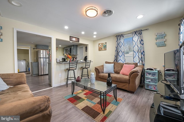 living room featuring dark wood-type flooring and washer / dryer