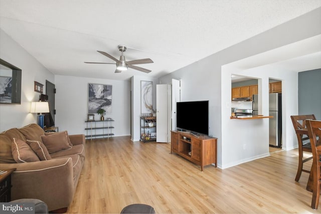 living room featuring ceiling fan and light wood-type flooring