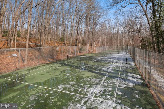 view of tennis court with a water view