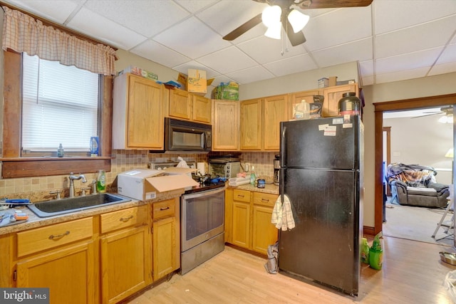 kitchen with black appliances, a paneled ceiling, sink, backsplash, and light hardwood / wood-style flooring