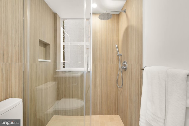 bathroom with toilet and a shower with door