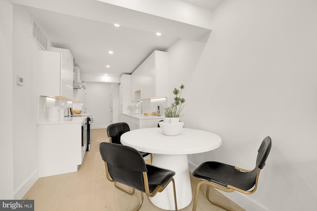 dining room featuring sink and light hardwood / wood-style flooring