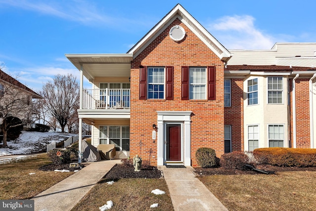 view of front of home with brick siding and a balcony