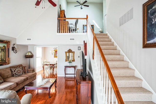 living room with visible vents, wood finished floors, a ceiling fan, and stairway