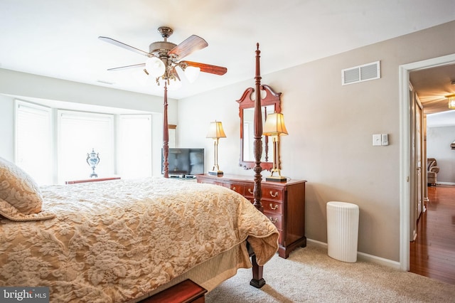 carpeted bedroom with a ceiling fan, baseboards, and visible vents