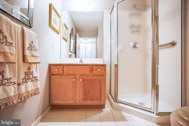 bathroom featuring tile patterned floors, toilet, a shower stall, baseboards, and vanity