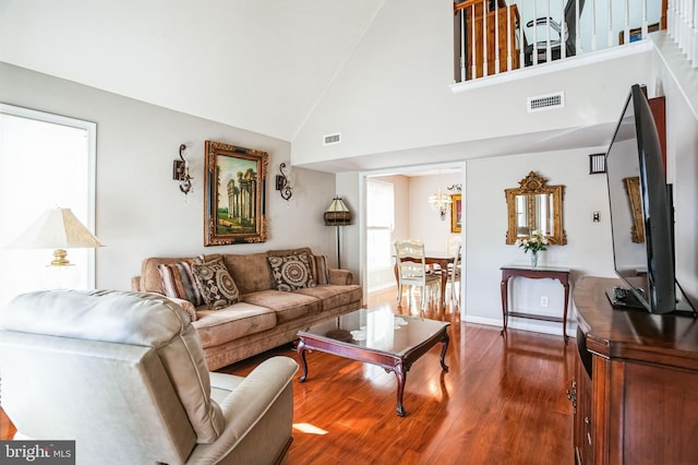 living room with visible vents, baseboards, high vaulted ceiling, and dark wood-style flooring