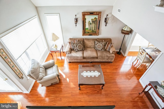 living room featuring visible vents, baseboards, and wood finished floors