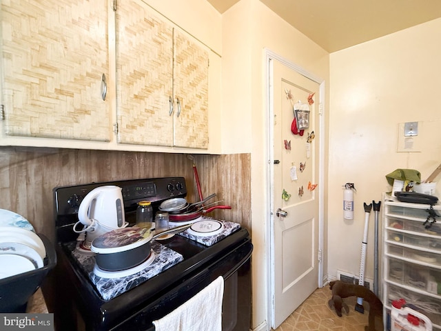 kitchen featuring light tile patterned flooring and black electric range