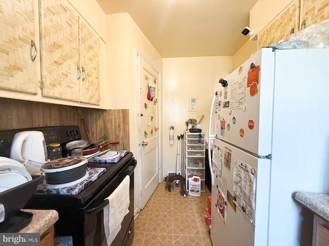 kitchen featuring black range with electric stovetop, white fridge, and light brown cabinetry