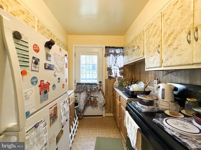 kitchen featuring electric range and white refrigerator