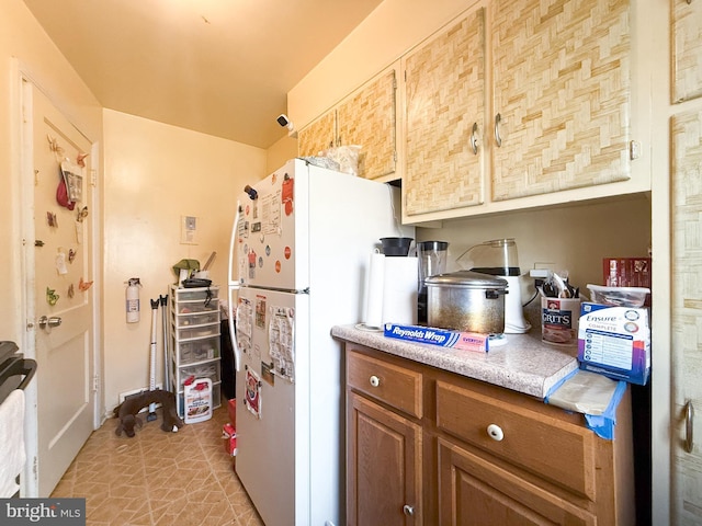 kitchen with white fridge and light tile patterned floors