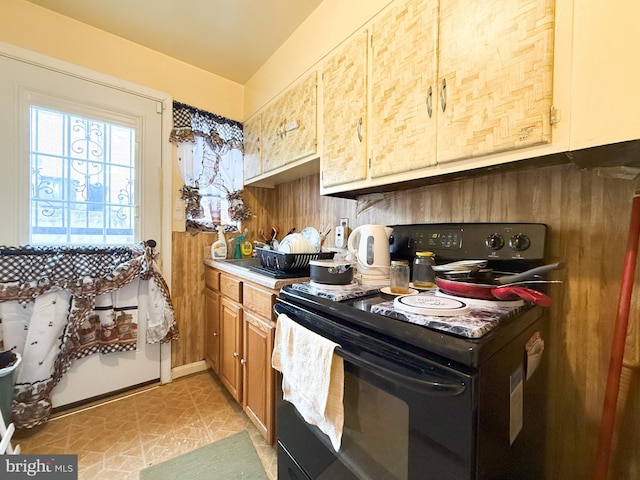 kitchen with electric range and wood walls