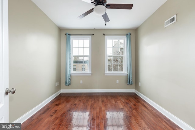 spare room with dark wood-type flooring and ceiling fan