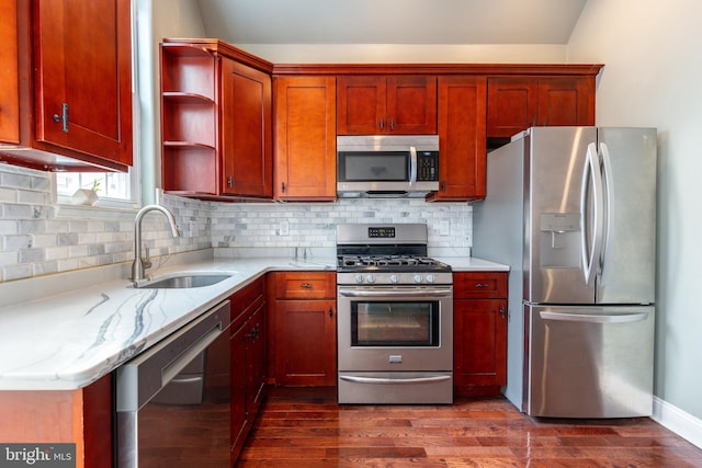 kitchen featuring dark hardwood / wood-style floors, tasteful backsplash, sink, stainless steel appliances, and light stone countertops