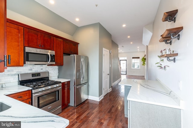 kitchen featuring tasteful backsplash, light stone countertops, dark hardwood / wood-style floors, and appliances with stainless steel finishes