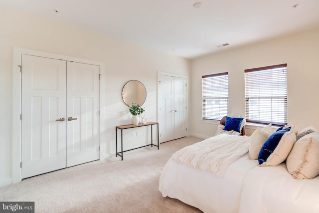 carpeted bedroom with two closets