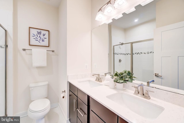 bathroom featuring toilet, tile patterned flooring, a shower with shower door, and vanity