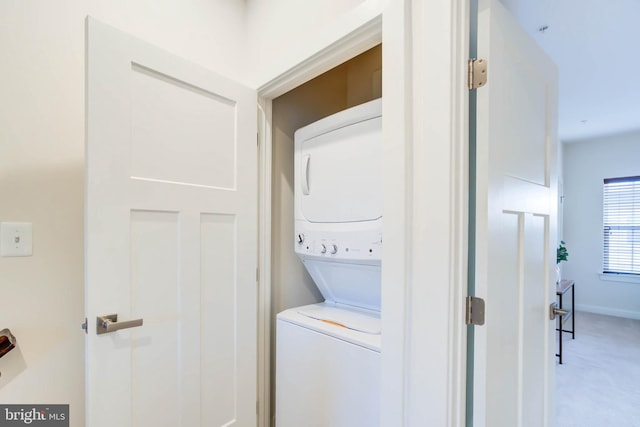 laundry area with stacked washing maching and dryer and carpet flooring