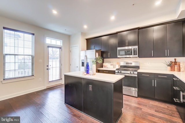 kitchen featuring dark hardwood / wood-style floors, a center island, and stainless steel appliances