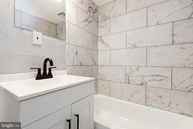 bathroom featuring tiled shower / bath and vanity