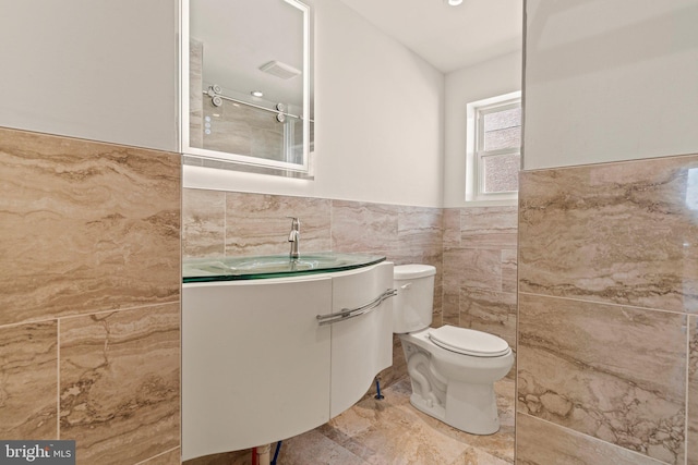 bathroom with toilet, tile walls, walk in shower, and vanity