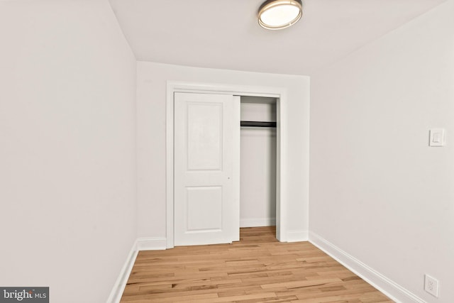 unfurnished bedroom with light wood-type flooring and a closet