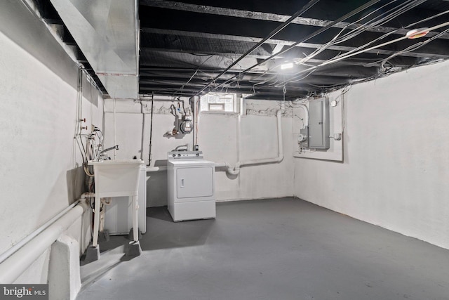 basement with electric panel and washing machine and clothes dryer