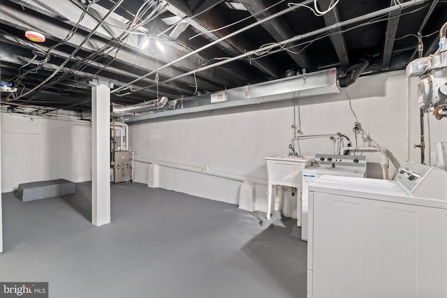 basement featuring washing machine and dryer and sink