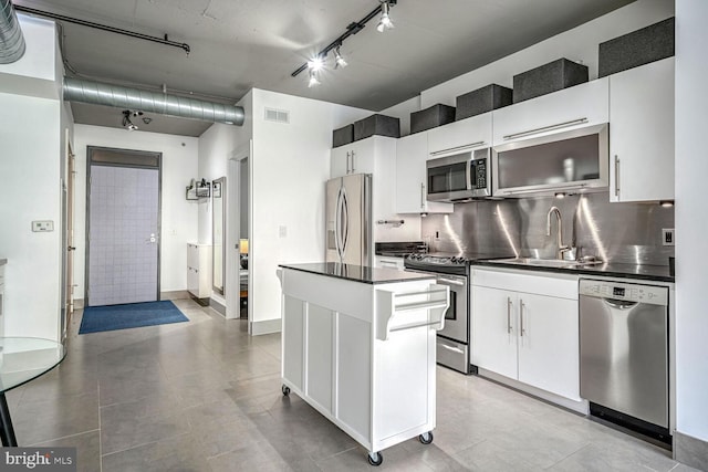 kitchen with backsplash, sink, white cabinets, and appliances with stainless steel finishes