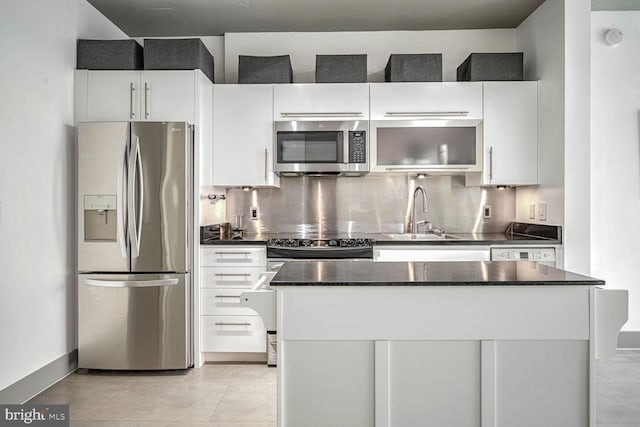 kitchen with sink, white cabinets, appliances with stainless steel finishes, and tasteful backsplash