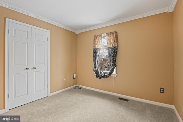 empty room featuring carpet floors and ornamental molding