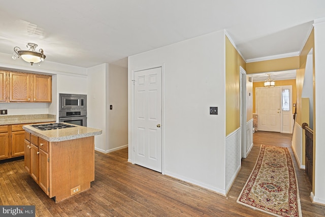 kitchen featuring stainless steel appliances, a center island, crown molding, and dark hardwood / wood-style flooring