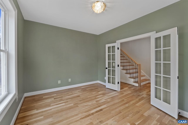 empty room featuring light wood-type flooring and french doors