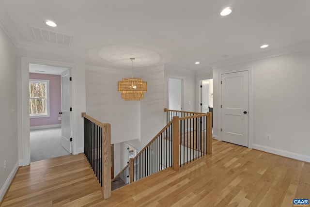 hall featuring ornamental molding and light hardwood / wood-style floors