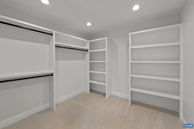 walk in closet with light carpet