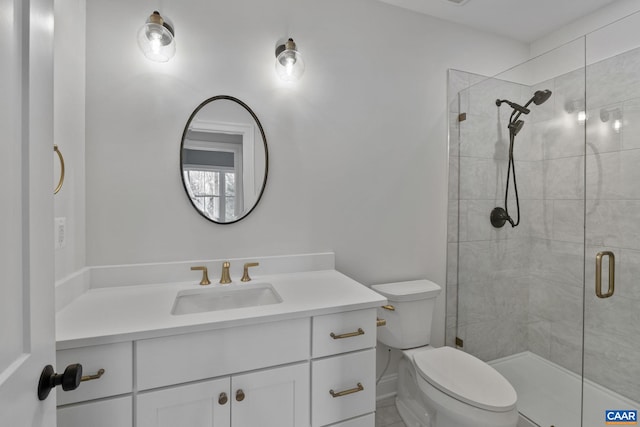 bathroom featuring toilet, a shower with door, and vanity