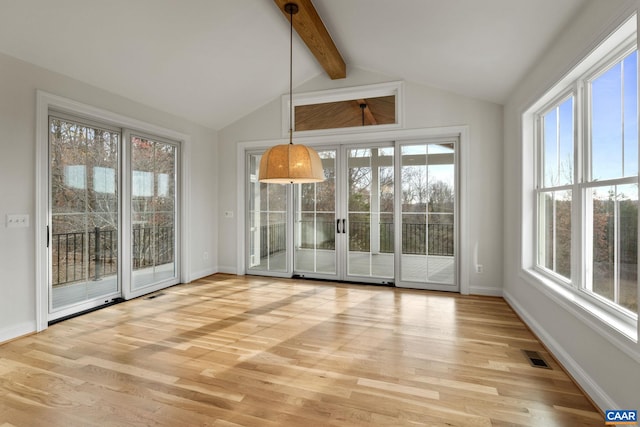 interior space with light hardwood / wood-style floors and vaulted ceiling with beams